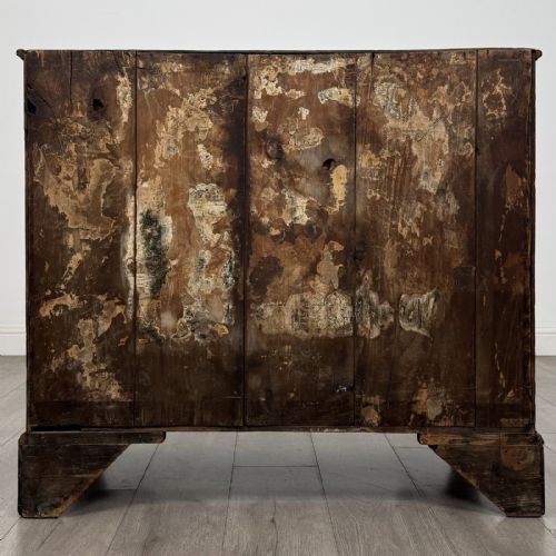 fig 4. An 18th-century dark oak Georgian chest of drawers featuring a two-short-over-three-long drawer configuration, brass handles, and bracket feet.