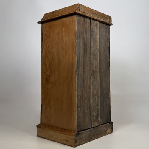 fig 3. An antique natural pine pot cupboard featuring a single arched panel door, turned wooden knob handle, side top galleries, and a solid plinth base.