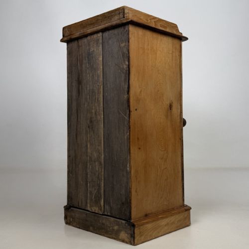 fig 5. An antique natural pine pot cupboard featuring a single arched panel door, turned wooden knob handle, side top galleries, and a solid plinth base.