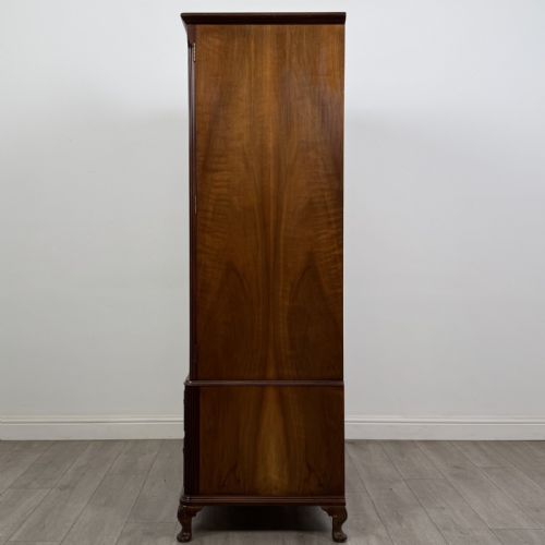 fig 2. A Queen Anne style burr walnut double-door wardrobe featuring two lower drawers, central metal hardware, and carved cabriole legs.