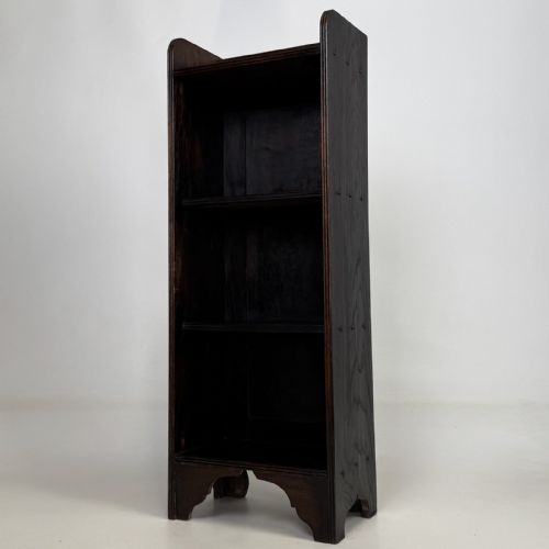 fig 1. A tall narrow dark oak open bookcase featuring a gallery top and three shelves above a shaped base.