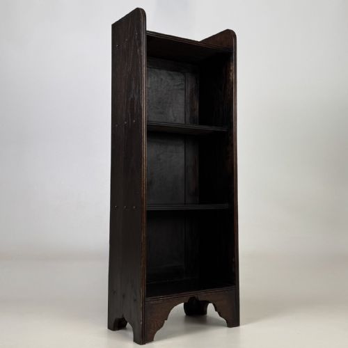 fig 7. A tall narrow dark oak open bookcase featuring a gallery top and three shelves above a shaped base.