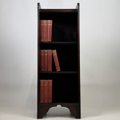 fig 8. A tall narrow dark oak open bookcase featuring a gallery top and three shelves above a shaped base.