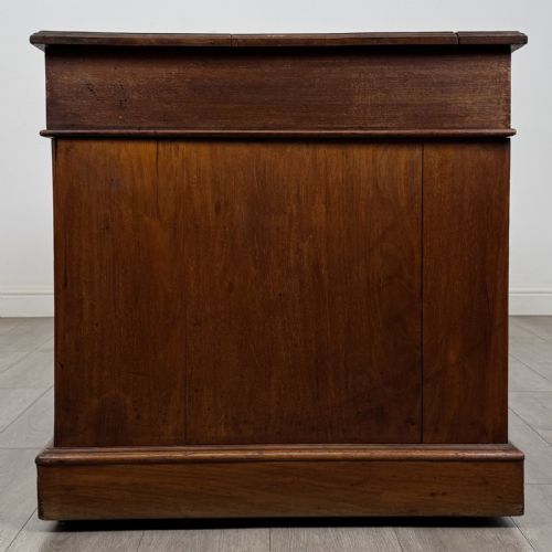 fig 2. A 19th-century walnut pedestal desk featuring nine drawers with brass handles and a plinth base.