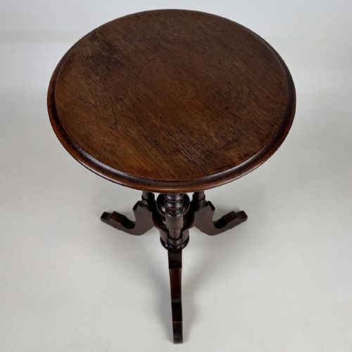 fig 4. A dark brown Victorian lamp table featuring a circular circular top supported by three bobbin-turned upright columns on a tripod base.