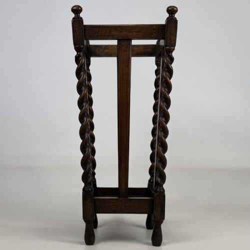 fig 4. An early 20th-century dark oak umbrella stand featuring four barley twist columns topped with small finials.
