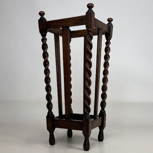 fig 5. An early 20th-century dark oak umbrella stand featuring four barley twist columns topped with small finials.