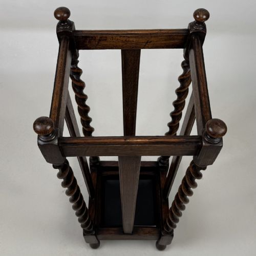 fig 6. An early 20th-century dark oak umbrella stand featuring four barley twist columns topped with small finials.