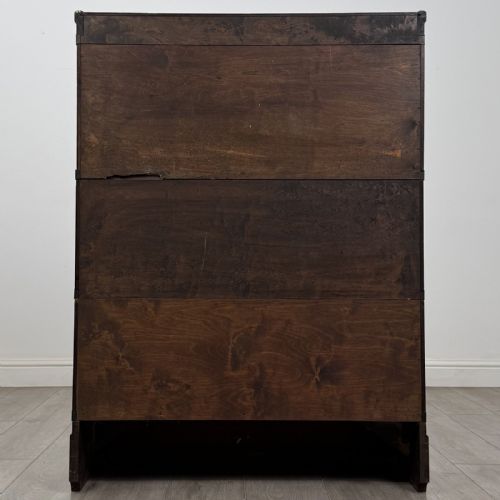 fig 4. A three-tier dark mahogany Globe Wernicke sectional bookcase featuring geometric leaded glass doors.