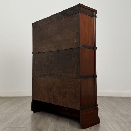 fig 5. A three-tier dark mahogany Globe Wernicke sectional bookcase featuring geometric leaded glass doors.