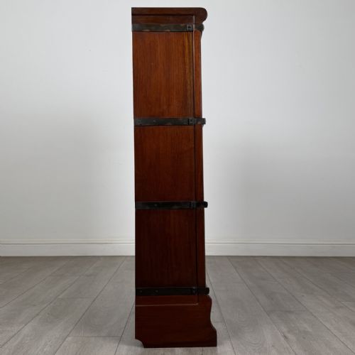 fig 6. A three-tier dark mahogany Globe Wernicke sectional bookcase featuring geometric leaded glass doors.