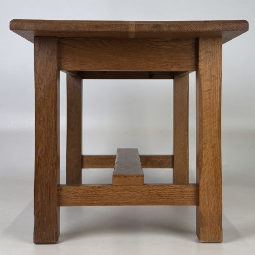 fig 2. A rectangular solid oak coffee table featuring simple square legs joined by low side stretchers in an Arts and Crafts style.