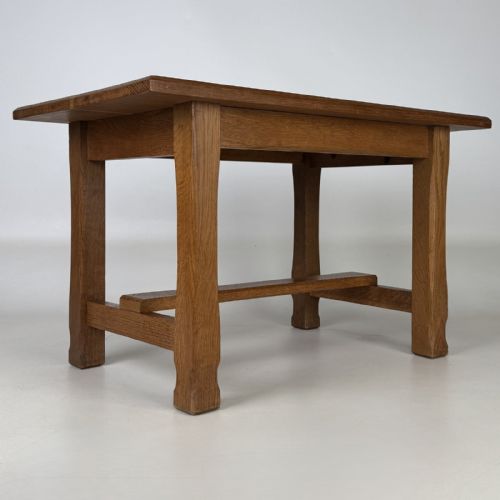 fig 3. A rectangular solid oak coffee table featuring simple square legs joined by low side stretchers in an Arts and Crafts style.
