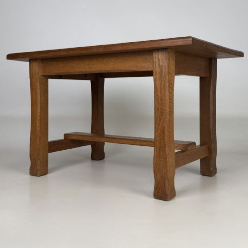 fig 5. A rectangular solid oak coffee table featuring simple square legs joined by low side stretchers in an Arts and Crafts style.