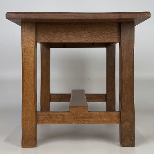 fig 6. A rectangular solid oak coffee table featuring simple square legs joined by low side stretchers in an Arts and Crafts style.