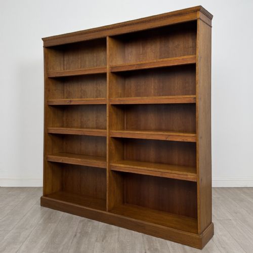 fig 1. A large 20th-century double-width open oak bookcase with a moulded cornice, central vertical divider, and ten spacious open shelves.