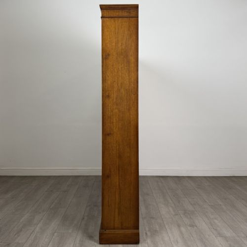 fig 2. A large 20th-century double-width open oak bookcase with a moulded cornice, central vertical divider, and ten spacious open shelves.