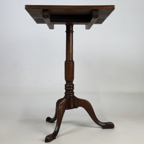 fig 1. An antique Georgian mahogany tilt-top tripod table featuring a square top supported by a turned central column and three cabriole legs with pad feet.