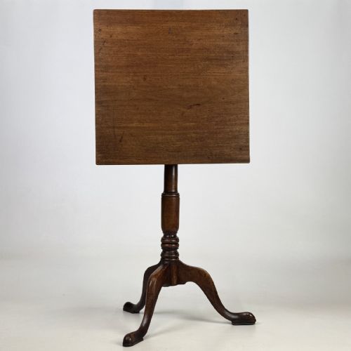 fig 3. An antique Georgian mahogany tilt-top tripod table featuring a square top supported by a turned central column and three cabriole legs with pad feet.