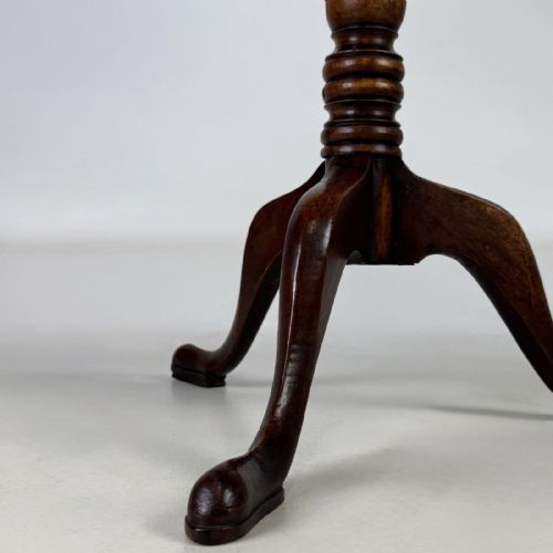 fig 7. An antique Georgian mahogany tilt-top tripod table featuring a square top supported by a turned central column and three cabriole legs with pad feet.