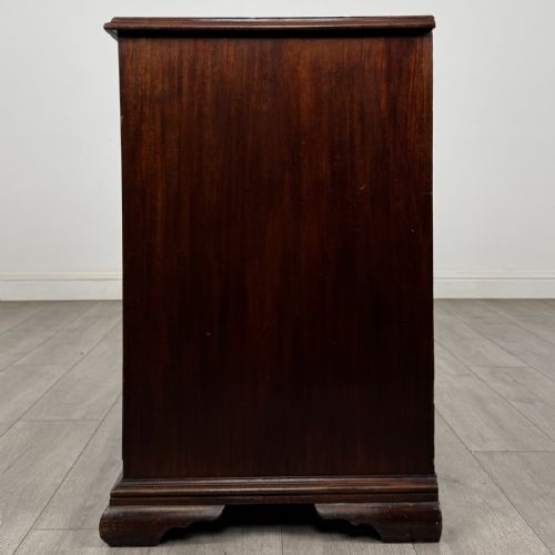 fig 2. An 18th-century Georgian dark mahogany chest of drawers featuring a two-over-three drawer arrangement with oval brass handles and bracket feet.