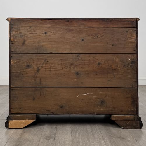 fig 4. An 18th-century Georgian dark mahogany chest of drawers featuring a two-over-three drawer arrangement with oval brass handles and bracket feet.