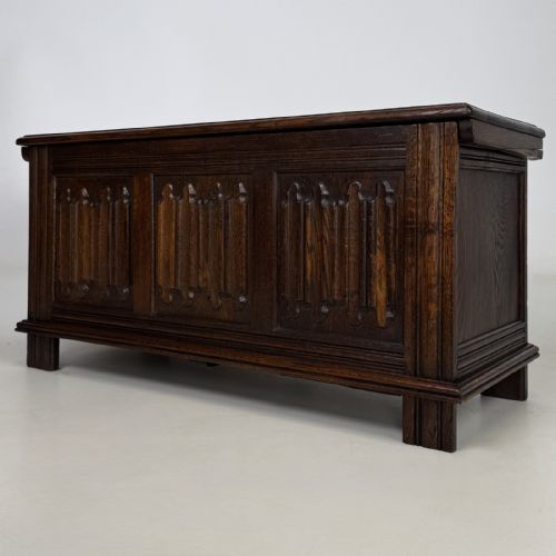 fig 1. A rectangular dark oak coffer with three carved linenfold panels along the front facade.