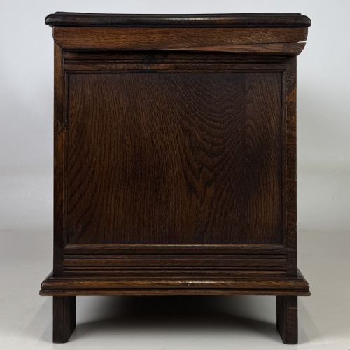 fig 2. A rectangular dark oak coffer with three carved linenfold panels along the front facade.