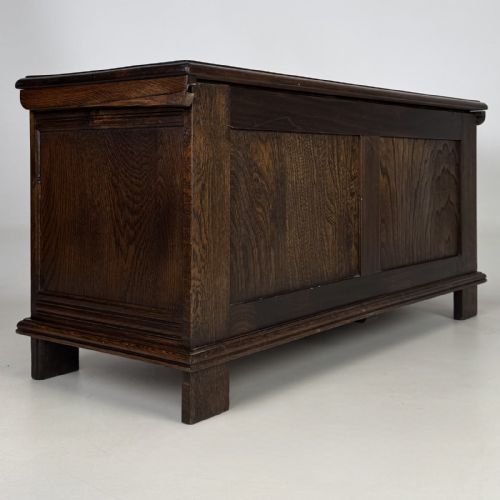 fig 3. A rectangular dark oak coffer with three carved linenfold panels along the front facade.