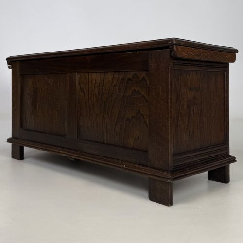 fig 5. A rectangular dark oak coffer with three carved linenfold panels along the front facade.