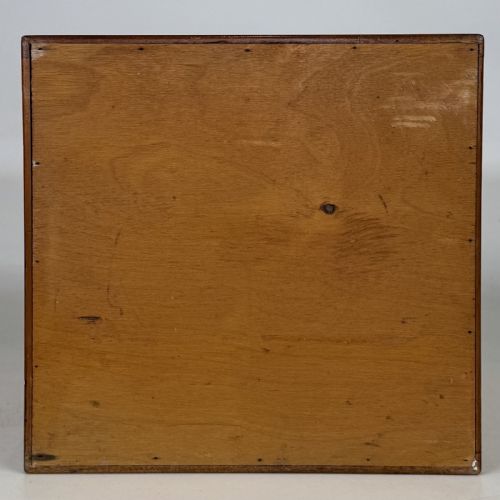 fig 4. An early 20th-century mahogany tabletop cabinet featuring five graduated drawers with dark round pull handles and a keyhole on the lowest drawer.