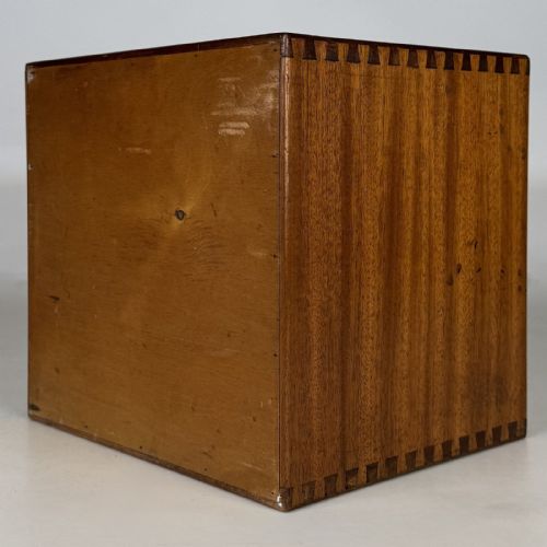 fig 5. An early 20th-century mahogany tabletop cabinet featuring five graduated drawers with dark round pull handles and a keyhole on the lowest drawer.