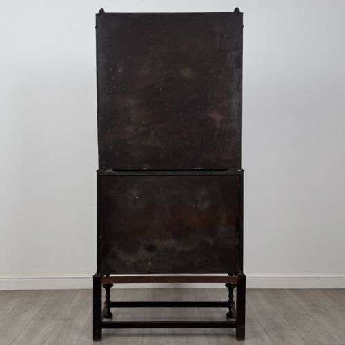 fig 6. A dark Jacobean style oak bureau bookcase with twin leaded glass upper doors, carved fall-front desk, two lower drawers, and turned legs.