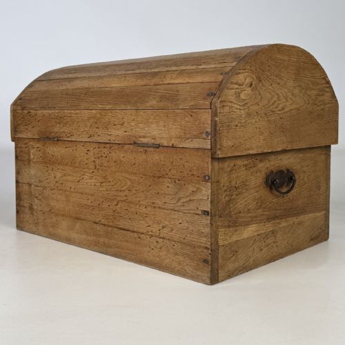 fig 5. A small light oak storage chest featuring a curved domed lid, metal stud details along the side edges, and a central wooden knob on the front.