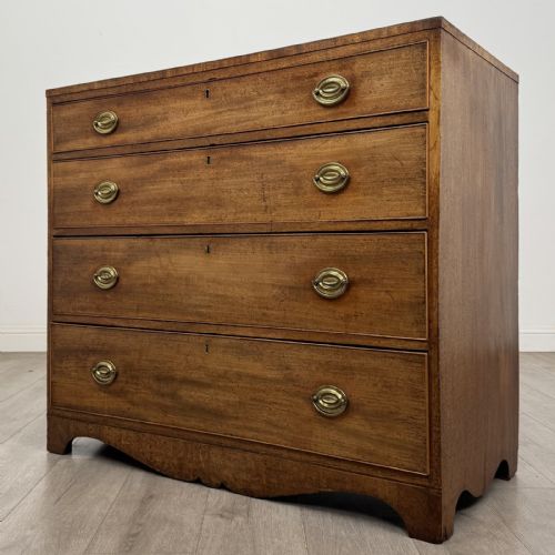 fig 1. A Georgian mahogany chest of drawers featuring four graduated drawers with oval brass handles and splayed bracket feet.
