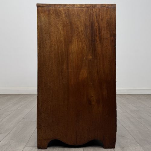 fig 2. A Georgian mahogany chest of drawers featuring four graduated drawers with oval brass handles and splayed bracket feet.