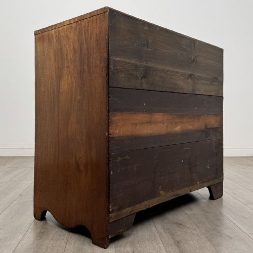 fig 3. A Georgian mahogany chest of drawers featuring four graduated drawers with oval brass handles and splayed bracket feet.