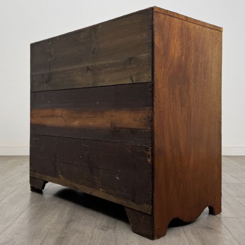 fig 5. A Georgian mahogany chest of drawers featuring four graduated drawers with oval brass handles and splayed bracket feet.