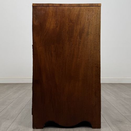 fig 6. A Georgian mahogany chest of drawers featuring four graduated drawers with oval brass handles and splayed bracket feet.