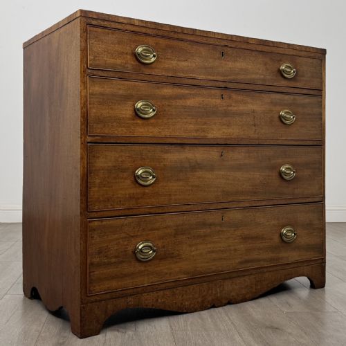 fig 7. A Georgian mahogany chest of drawers featuring four graduated drawers with oval brass handles and splayed bracket feet.