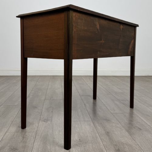fig 3. A small Georgian style mahogany writing desk featuring five drawers with brass handles and straight tapered legs.