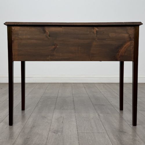 fig 4. A small Georgian style mahogany writing desk featuring five drawers with brass handles and straight tapered legs.
