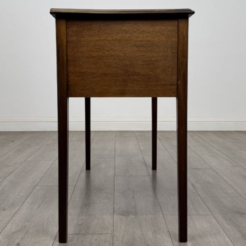 fig 6. A small Georgian style mahogany writing desk featuring five drawers with brass handles and straight tapered legs.