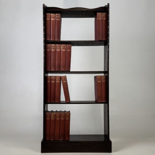 fig 1. A tall and narrow early 20th-century dark oak open bookcase with five shelf levels and a shaped top gallery.