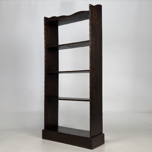 fig 2. A tall and narrow early 20th-century dark oak open bookcase with five shelf levels and a shaped top gallery.