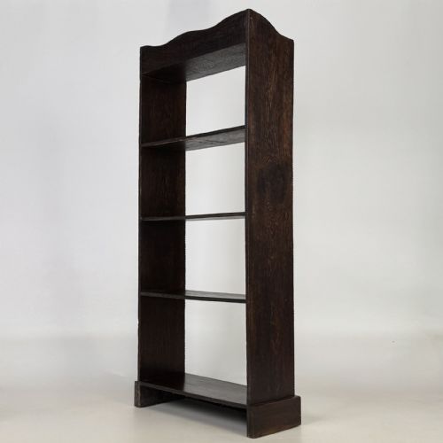 fig 6. A tall and narrow early 20th-century dark oak open bookcase with five shelf levels and a shaped top gallery.