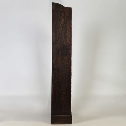 fig 7. A tall and narrow early 20th-century dark oak open bookcase with five shelf levels and a shaped top gallery.
