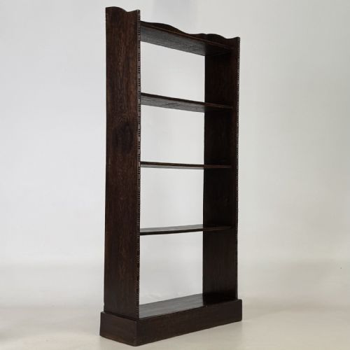 fig 8. A tall and narrow early 20th-century dark oak open bookcase with five shelf levels and a shaped top gallery.