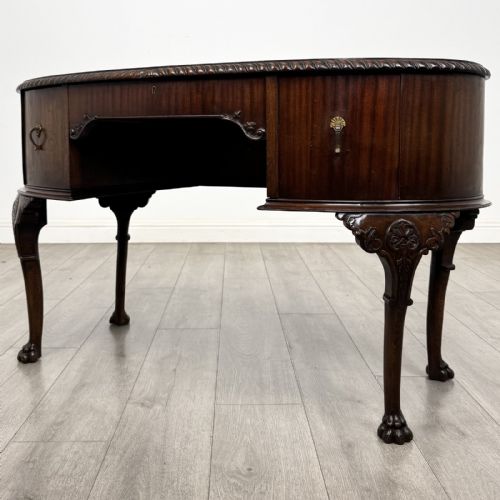 fig 1. A Chippendale style mahogany oval desk featuring cabriole legs with carved knees, ball-and-claw feet, side drawers, and a central kneehole.