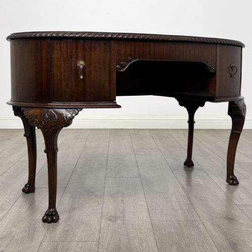 fig 7. A Chippendale style mahogany oval desk featuring cabriole legs with carved knees, ball-and-claw feet, side drawers, and a central kneehole.